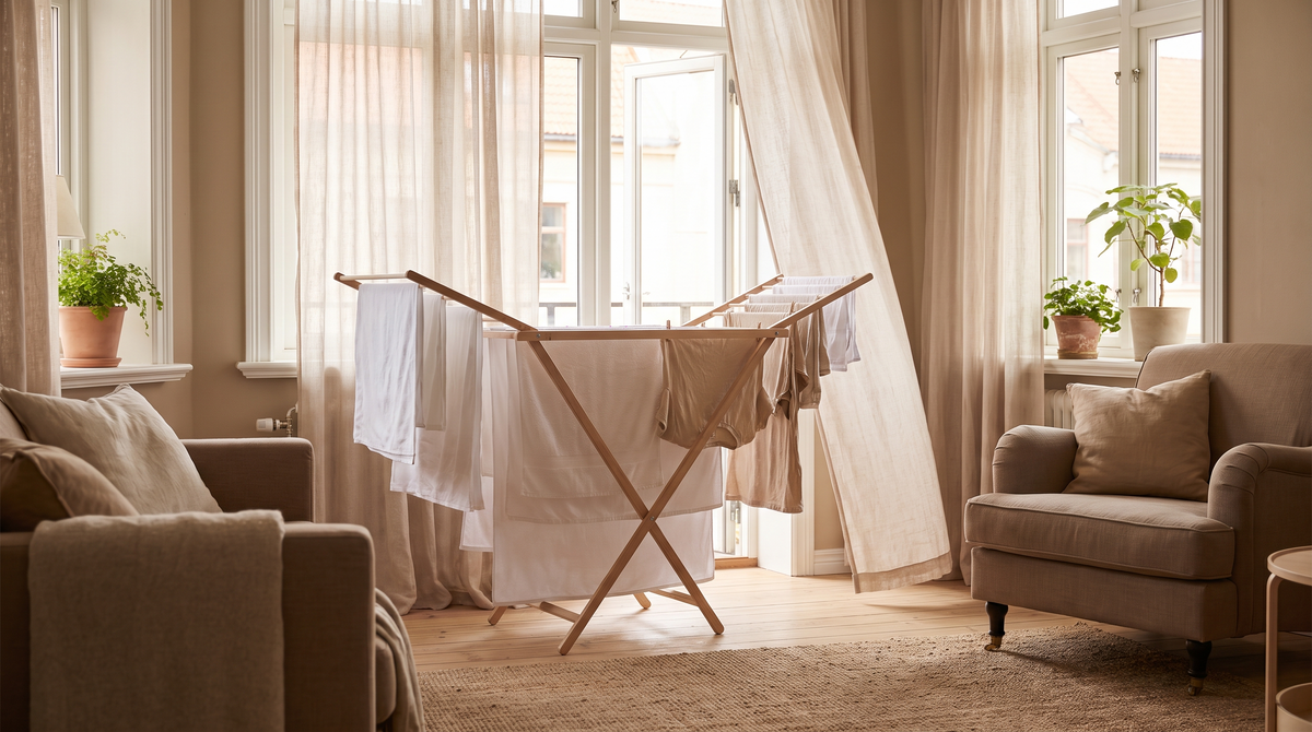 Droogrek met lichte was bij een open raam met vitrage in een lichte woonkamer