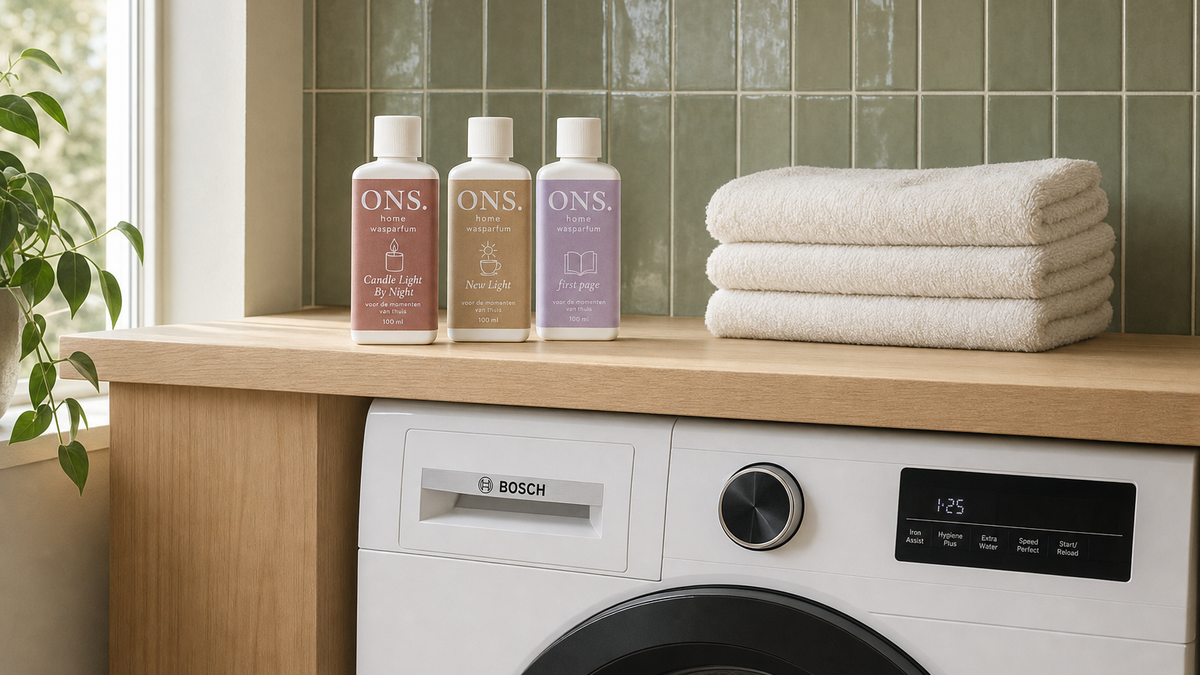 De drie ONS Home wasparfumflesjes op een houten blad in een waskamer met groene tegels en Bosch-wasmachine